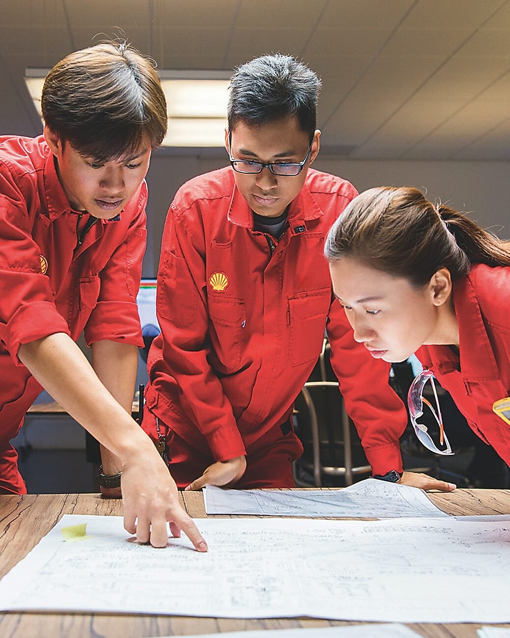 Three people looking at plans
