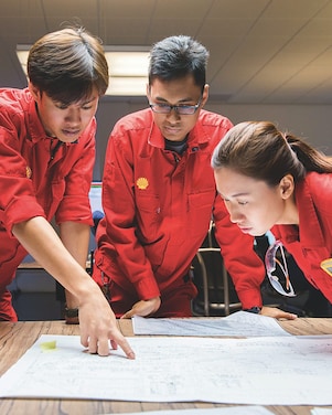 Three people looking at plans