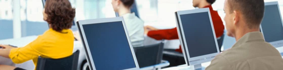  rear view of four business executives using computers in an office