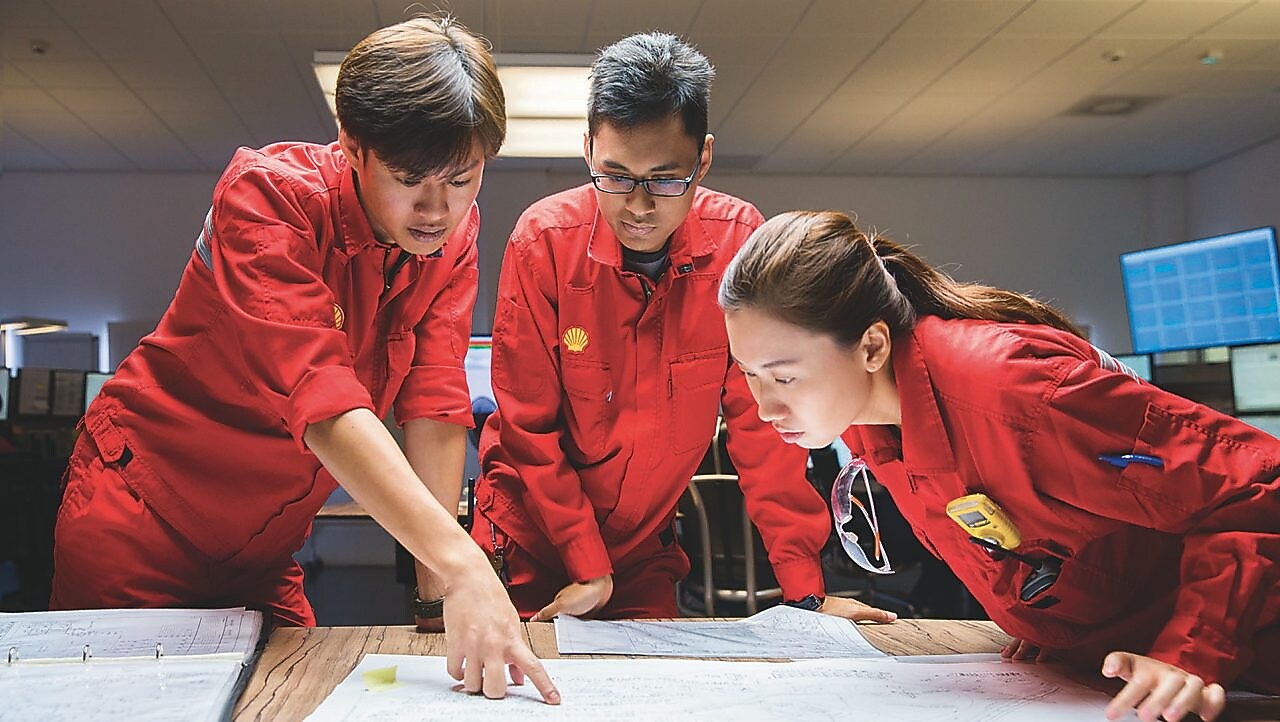 Three people looking at plans