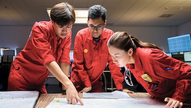 Three people looking at plans