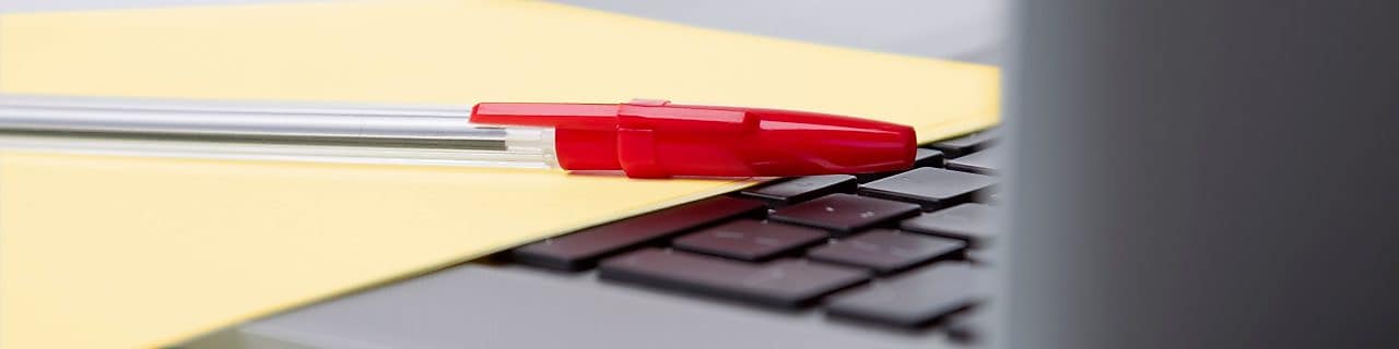 Red pen and yellow sheet of paper on the keyboard of a laptop BUSINESS ENVIRONMENT UK 2010