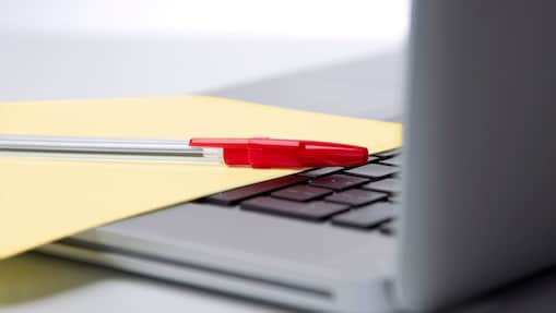 Red pen and yellow sheet of paper on the keyboard of a laptop BUSINESS ENVIRONMENT UK 2010